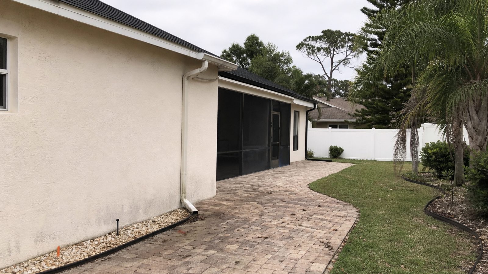 Florida home exterior showing roof, patio pavers, irrigation edge, screened lanai and service-condition details